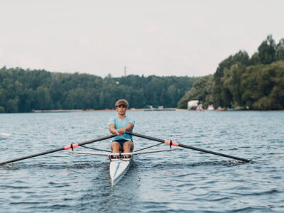 Sportsman single scull man rower rowing at competition boat regatta. 
